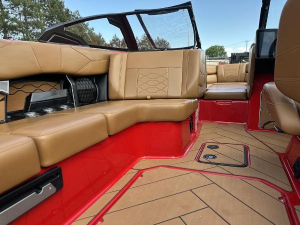 Slide: The Image of 2025 Malibu 23 LSV boat interior with tan leather seats and red accents. - 13
