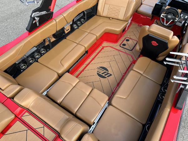 Slide: The Image of Luxurious interior of 2025 Malibu 23 LSV boat with tan leather seating and red accents. - 15