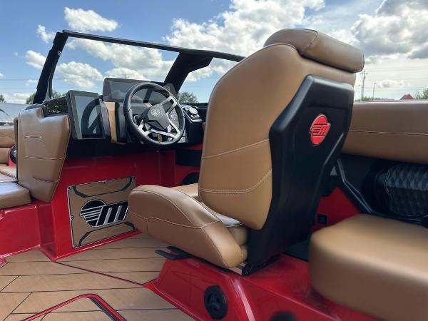 Slide: The Image of 2025 Malibu 23 LSV boat interior with tan seats and modern dashboard. - 18