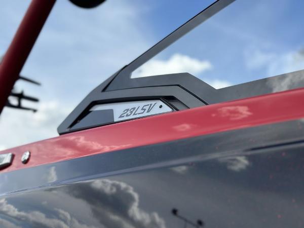 Slide: The Image of 2025 Malibu 23 LSV boat detail with sleek design against a cloudy sky. - 2