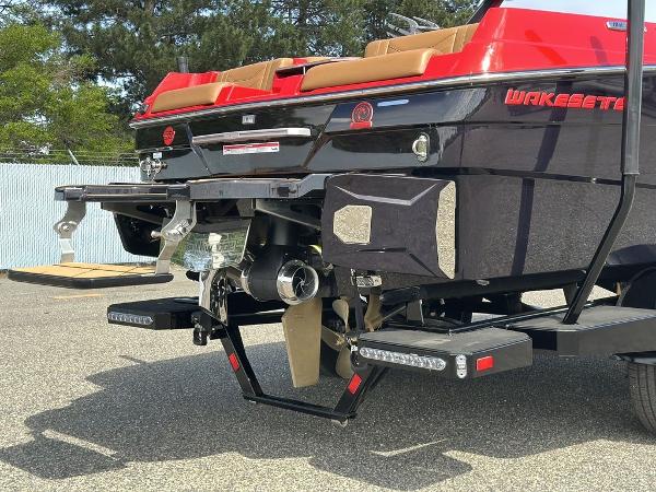 Slide: The Image of 2025 Malibu 23 LSV boat rear view, showcasing propeller and wakeboard features. - 22