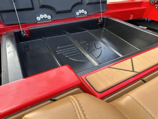 Slide: The Image of 2025 Malibu 23 LSV boat storage compartment with red and tan interior detailing. - 7