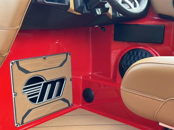 Slide: The Image of Interior of 2025 Malibu 23 LSV boat with red paneling and tan seating. - 9