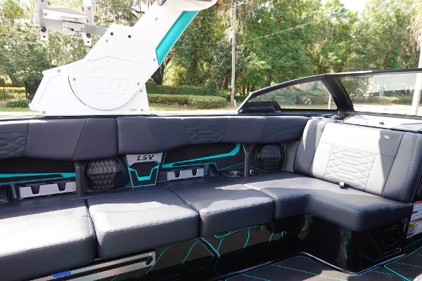 Slide: The Image of 2023 Malibu 25 LSV boat interior with black and teal seating, modern design. - 16