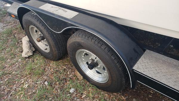 Slide: The Image of Trailer wheels of a 1998 Malibu Sunsetter VLX boat on grass. - 23