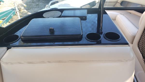 Slide: The Image of 1998 Malibu Sunsetter VLX boat interior with cup holders and storage compartments. - 9