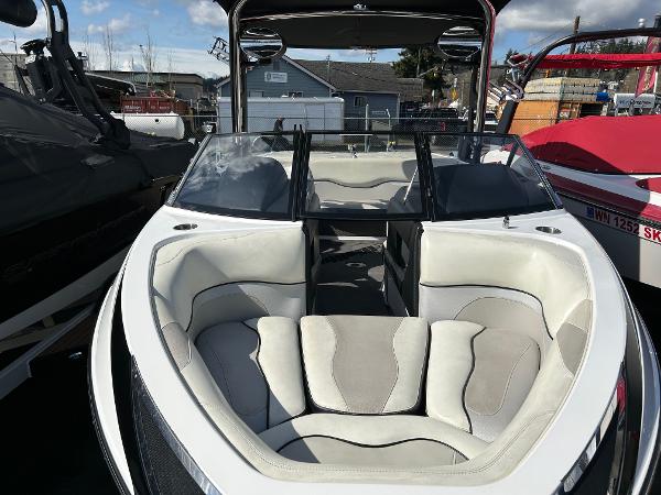 Slide: The Image of 2013 Malibu Wakesetter 20 VTX boat with white and gray interior, docked outdoors. - 2