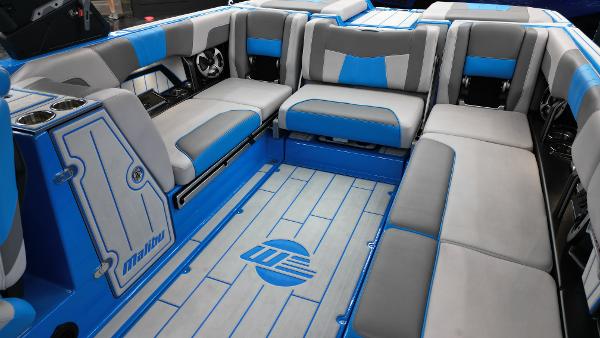 Slide: The Image of 2021 Malibu Wakesetter 24 MXZ interior with blue and gray seating and flooring. - 10