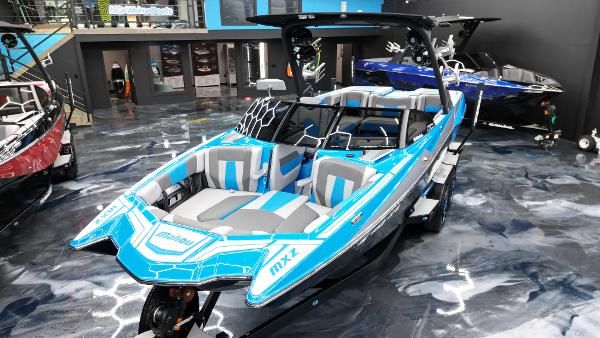 Slide: The Image of 2021 Malibu Wakesetter 24 MXZ boat in showroom, vibrant blue and gray design. - 3