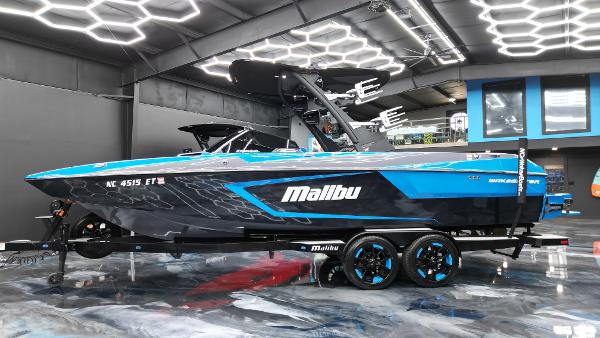 Slide: The Image of 2021 Malibu Wakesetter 24 MXZ boat in showroom, blue and black design. - 4