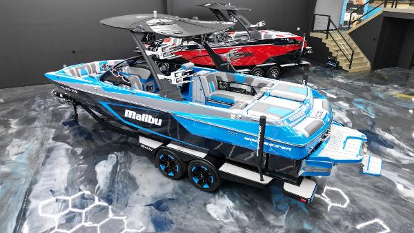 Slide: The Image of 2021 Malibu Wakesetter 24 MXZ boat in showroom, blue and black design. - 6