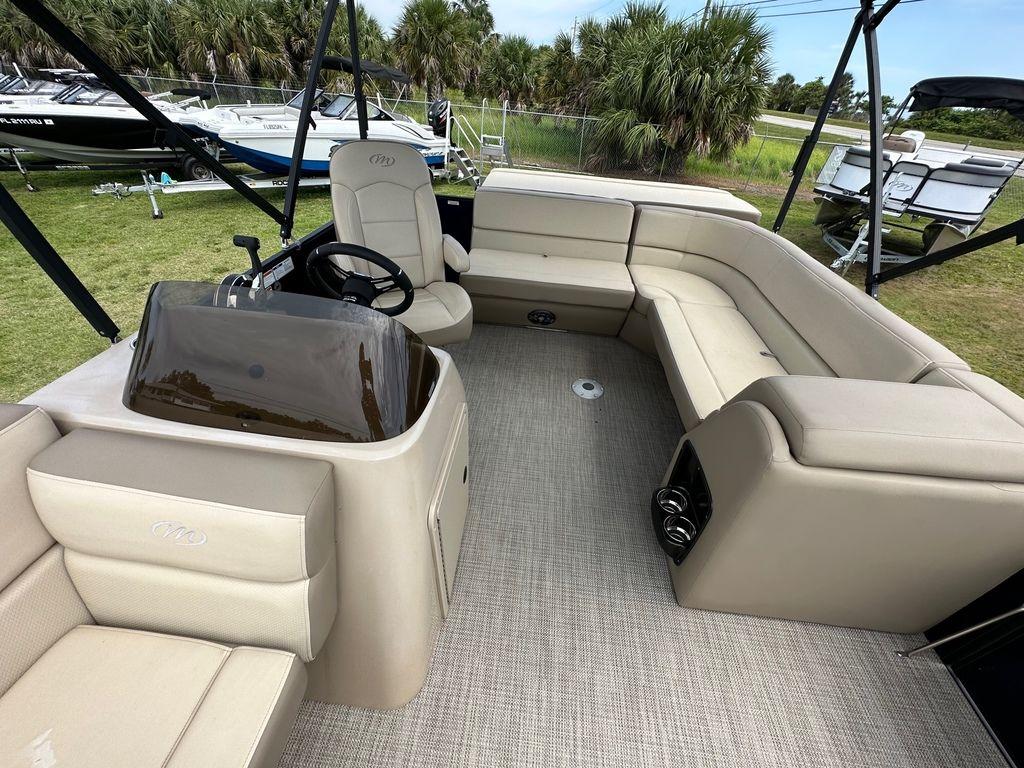 Slide: The Image of 2022 Manitou 18 Aurora LE Standard Twin Tube interior with beige seating and steering console. - 13