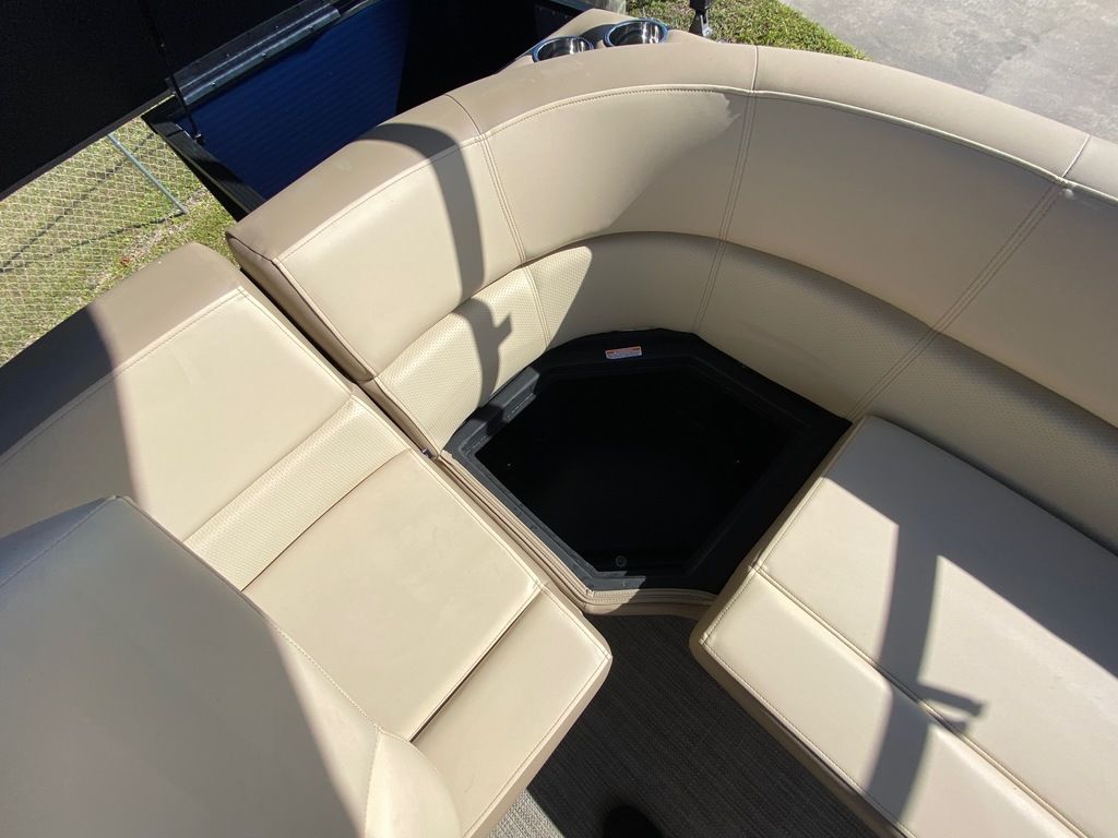 Slide: The Image of 2022 Manitou 18 Aurora LE Standard Twin Tube boat with beige seating and storage compartment. - 23
