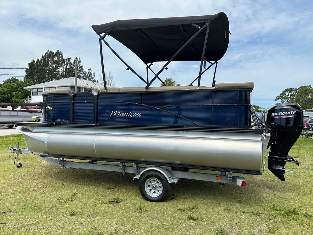 Slide: The Image of 2022 Manitou 18 Aurora LE Standard Twin Tube pontoon boat on trailer. - 7