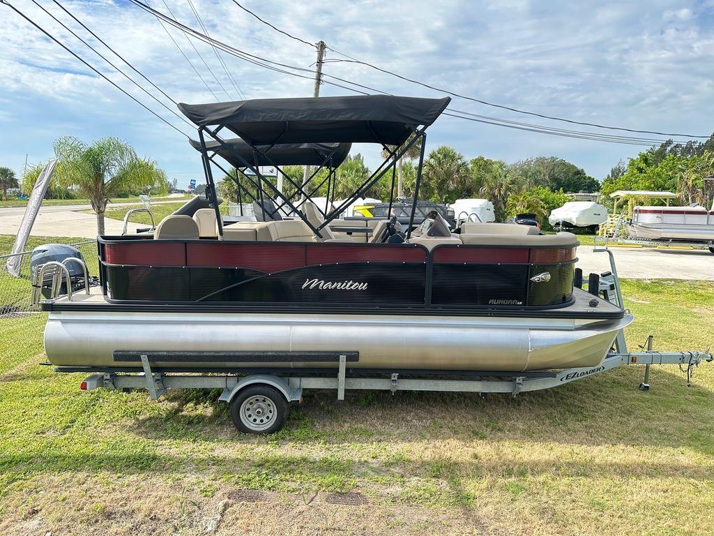 Slide: The Image of 2022 Manitou 20 Aurora LE Angler Full Front Twin Tube pontoon boat on trailer. - 0