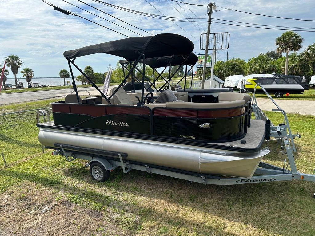 Slide: The Image of 2022 Manitou 20 Aurora LE Angler Full Front Twin Tube pontoon boat on trailer. - 1