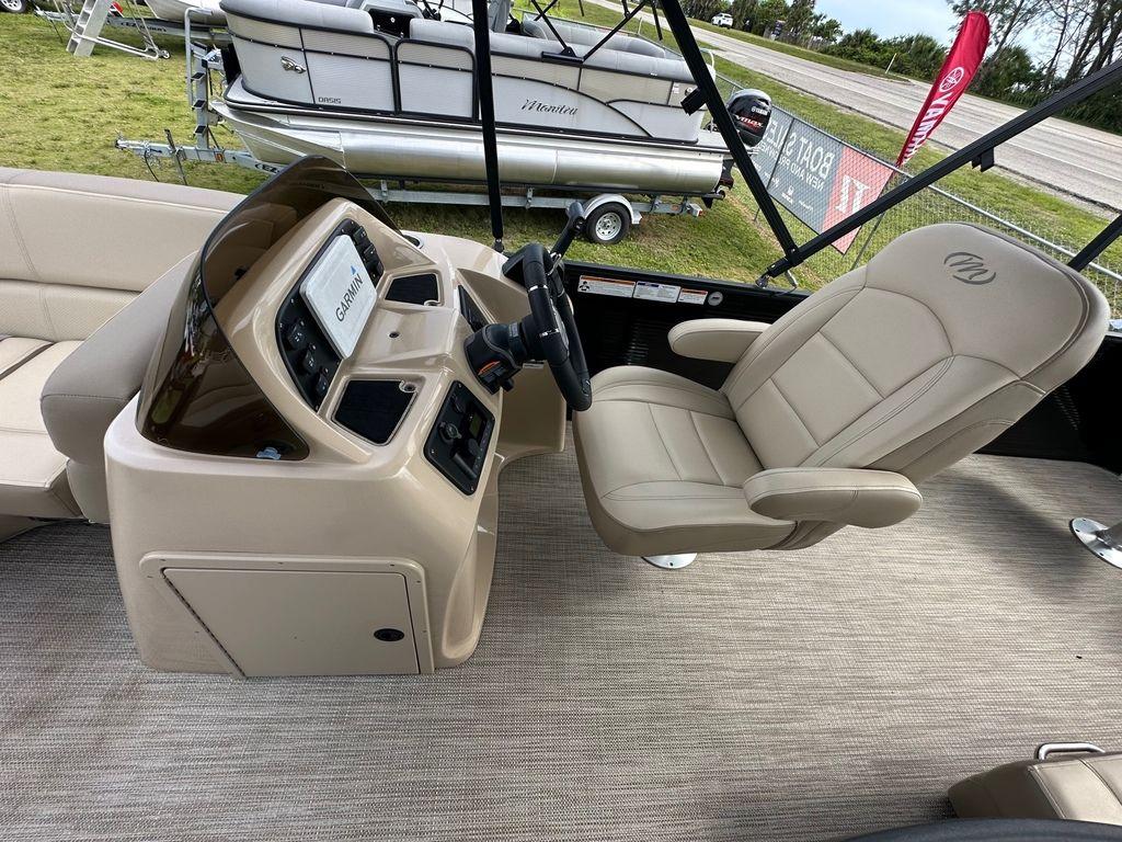 Slide: The Image of 2022 Manitou 20 Aurora LE Angler Full Front Twin Tube boat interior with captain's chair and control console. - 13