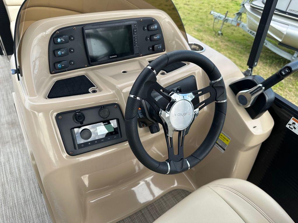Slide: The Image of 2022 Manitou 20 Aurora LE Angler Full Front Twin Tube boat dashboard with steering wheel and controls. - 18