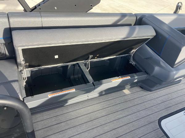 Slide: The Image of 2024 Manitou 24 EXPLORE SWITCHBACK boat with open under-seat storage compartments. - 18