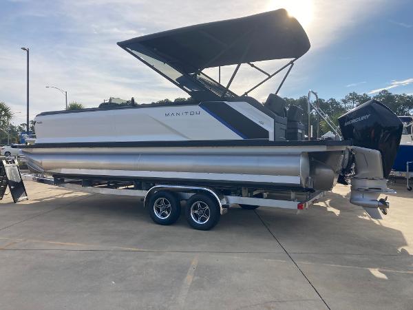 Slide: The Image of 2024 Manitou 24 EXPLORE SWITCHBACK pontoon boat with canopy on trailer. - 2
