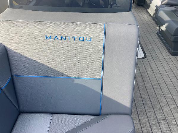 Slide: The Image of 2024 Manitou 24 EXPLORE SWITCHBACK boat interior with grey and blue seating. - 6