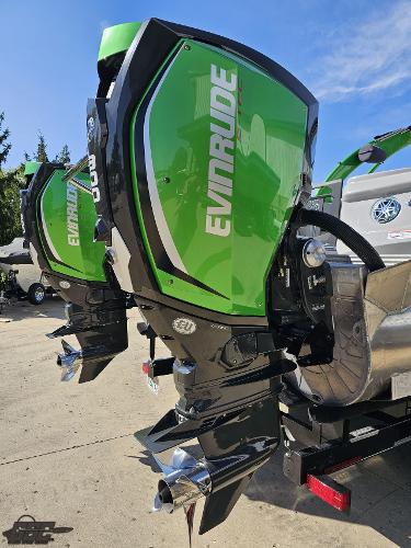 Slide: The Image of 2021 Manitou 25 X-Plode with green Evinrude outboard motors, parked on a sunny day. - 38