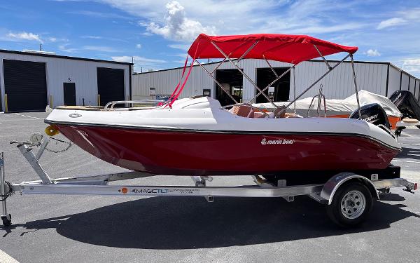 Slide: The Image of 2025 MarinBoat Tango with red canopy on trailer, parked outdoors. - 1