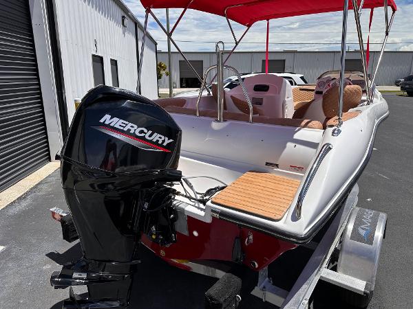 Slide: The Image of 2025 MarinBoat Tango with Mercury engine, red canopy, parked on trailer. - 5