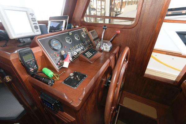 Slide: The Image of 1983 Marine Trader 40 Double Cabin helm with navigation instruments and wooden steering wheel. - 17