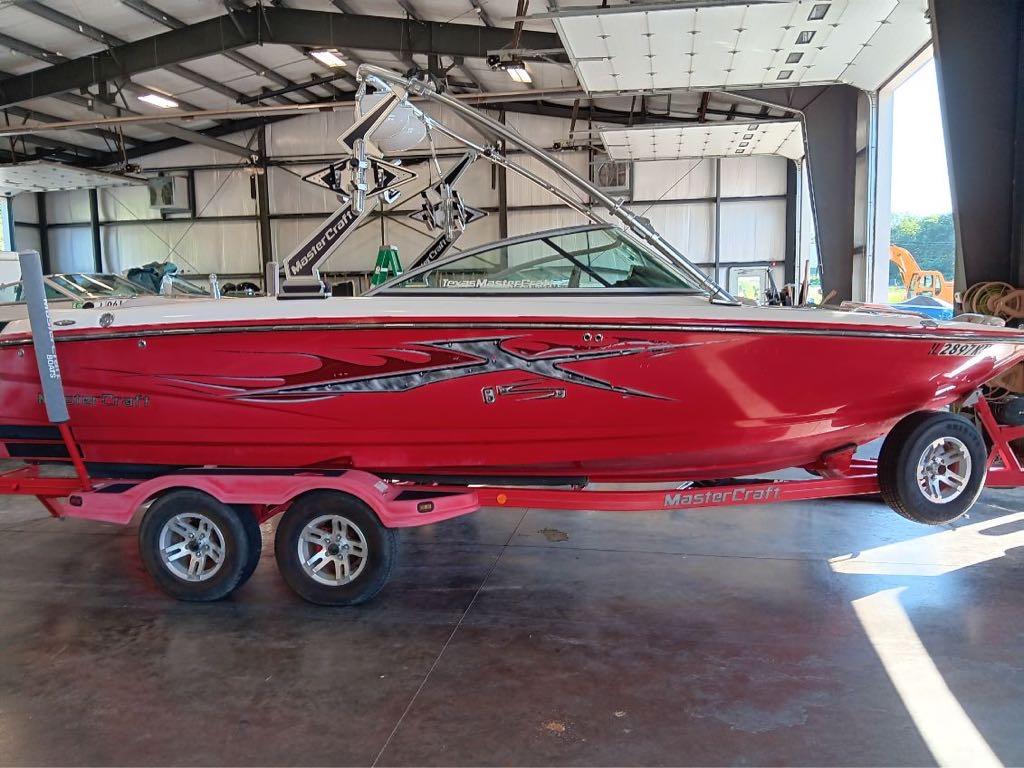 Slide: The Image of 2007 MasterCraft X15 red boat on trailer in indoor storage facility. - 1
