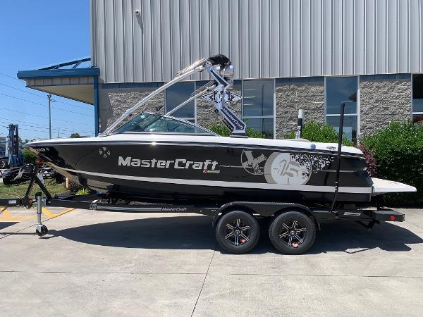 Slide: The Image of 2009 MasterCraft X15 boat on trailer outside industrial building. - 0