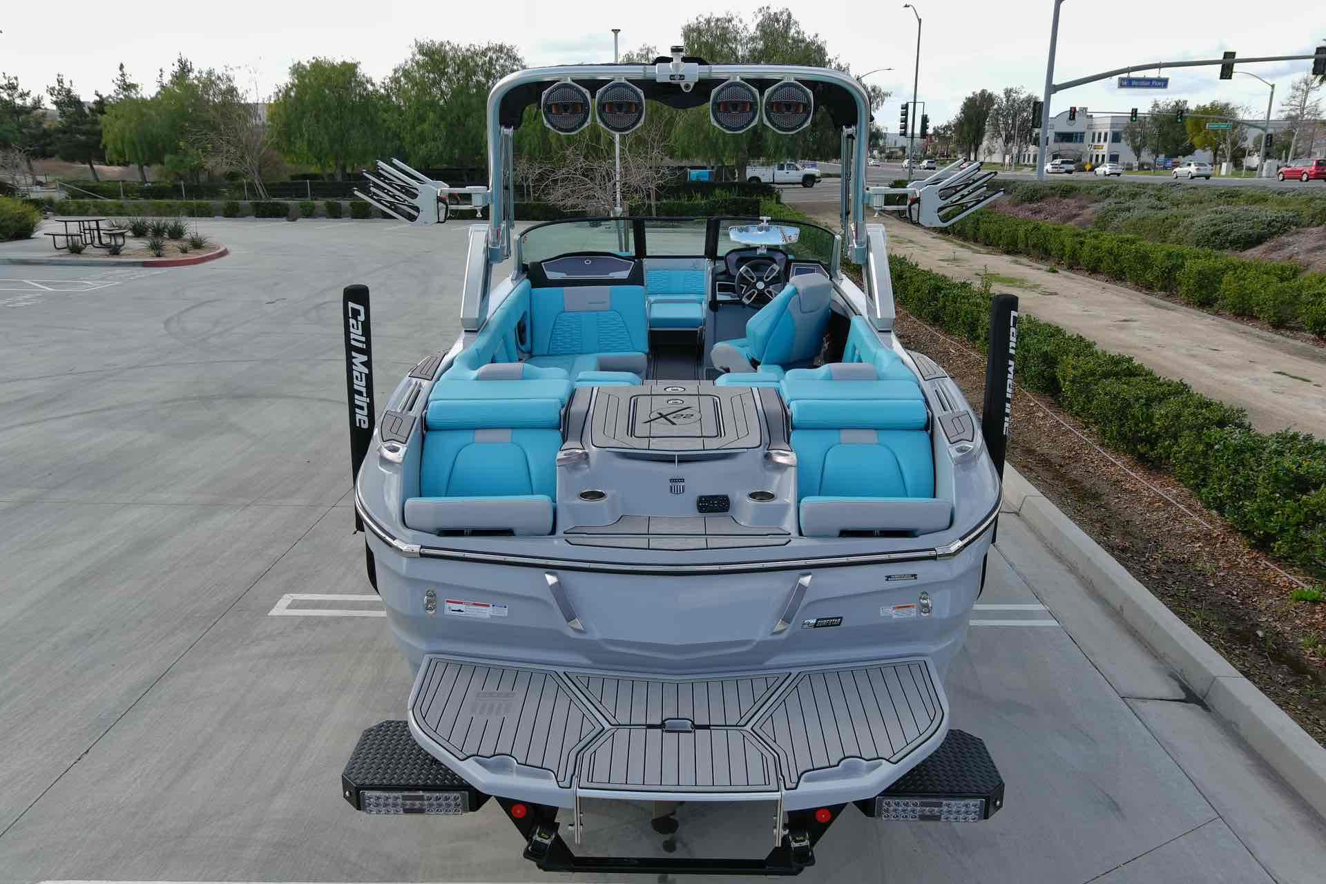 Slide: The Image of 2023 MasterCraft X22 boat with blue and gray interior, parked in a lot. - 4