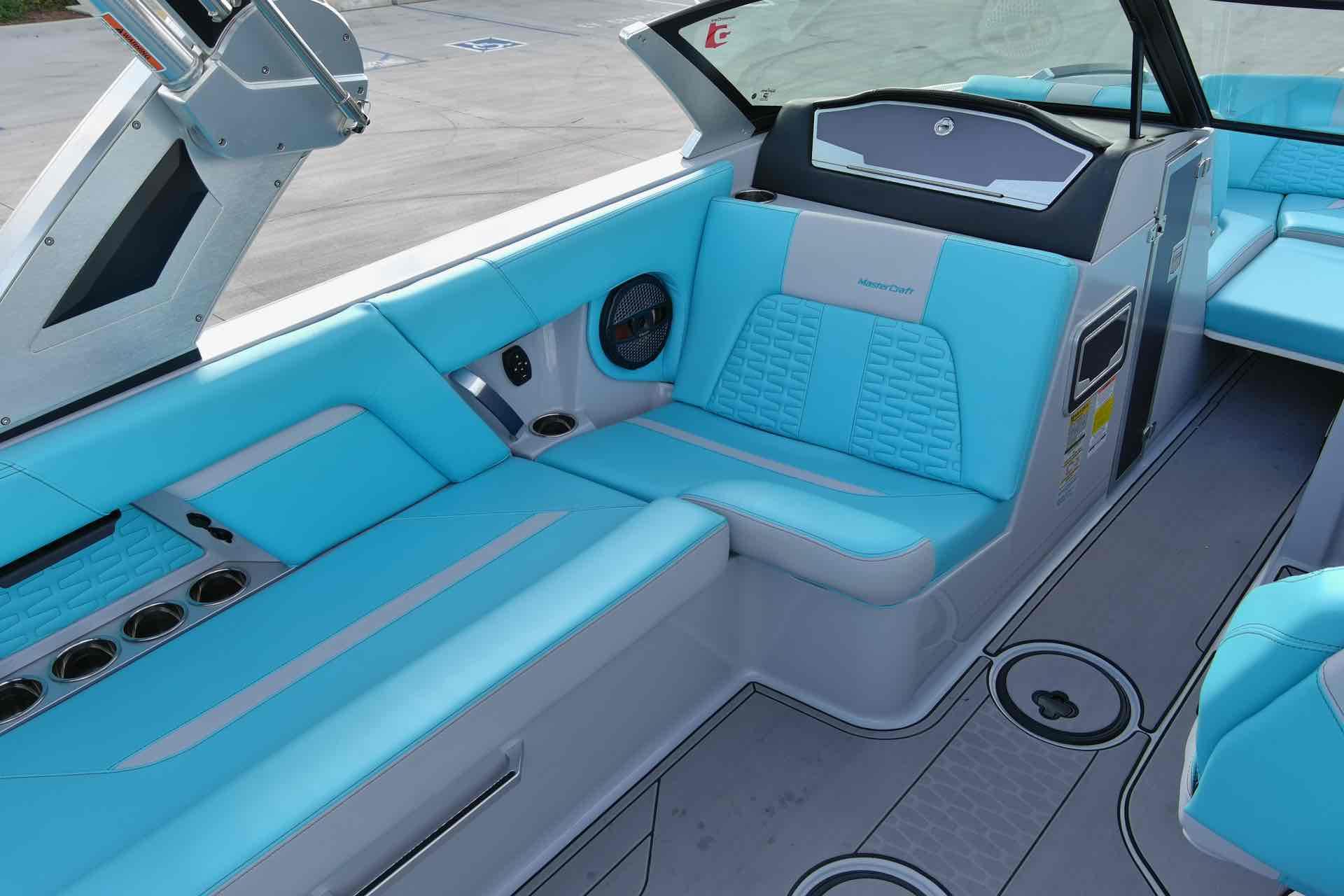 Slide: The Image of 2023 MasterCraft X22 boat interior with blue and gray seating. - 8