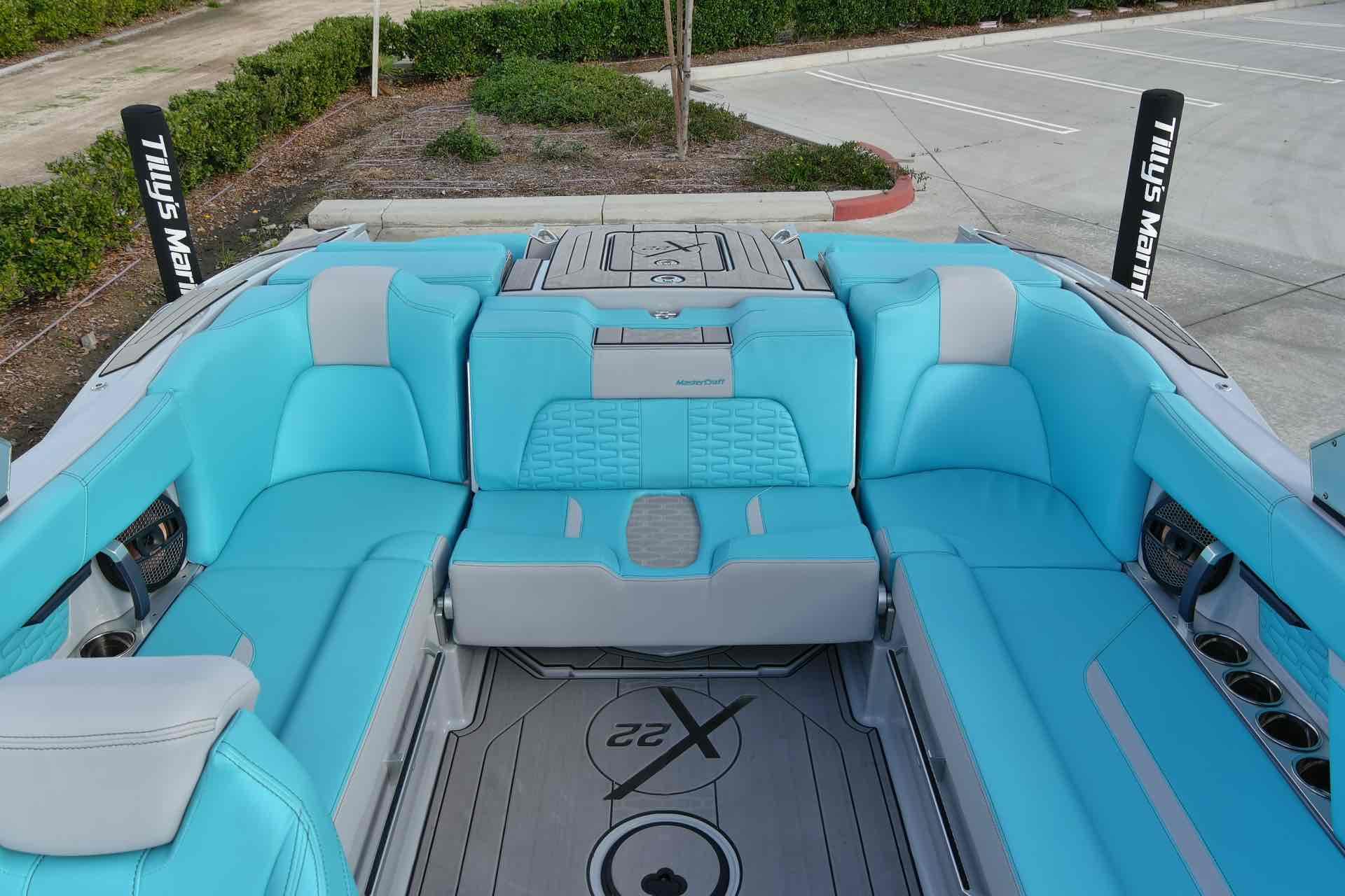 Slide: The Image of 2023 MasterCraft X22 boat interior with turquoise seating and gray accents. - 9