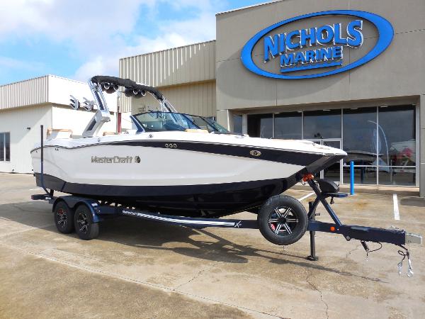 Slide: The Image of 2024 MasterCraft X24 boat on trailer at Nichols Marine dealership. - 2