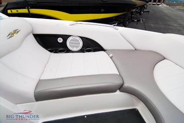 Slide: The Image of 2005 MasterCraft X45 boat interior with white and gray seating, speaker, and cup holders. - 46