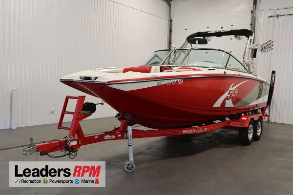 Slide: The Image of 2013 MasterCraft X55 red boat on trailer in showroom. - 1
