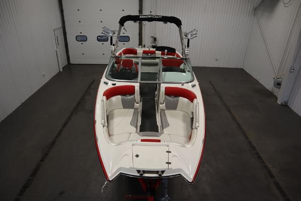 Slide: The Image of 2013 MasterCraft X55 boat with red and white interior in a storage facility. - 10