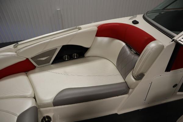 Slide: The Image of 2013 MasterCraft X55 boat interior with white, red, and gray seating. - 19