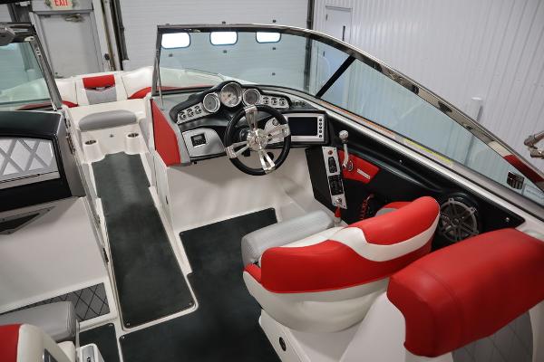 Slide: The Image of 2013 MasterCraft X55 boat interior with red and white seats, modern dashboard, and steering wheel. - 26