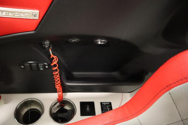 Slide: The Image of 2013 MasterCraft X55 boat interior with red and black accents, cup holders, and control panel. - 45