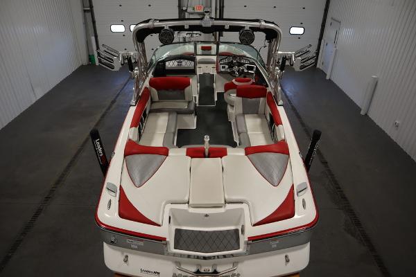 Slide: The Image of 2013 MasterCraft X55 boat interior with red and white seating in a garage. - 9