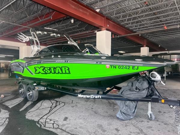 Slide: The Image of 2013 MasterCraft XStar boat in bright green on a trailer in a garage. - 0