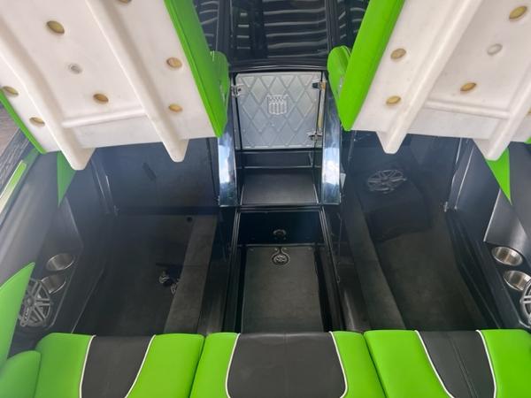 Slide: The Image of 2013 MasterCraft XStar interior with green and black seating, open storage compartments. - 13