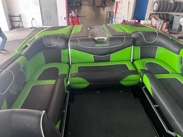 Slide: The Image of 2013 MasterCraft XStar boat interior with green and black seating. - 32