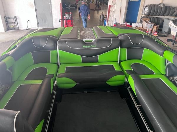 Slide: The Image of 2013 MasterCraft XStar boat interior with green and black seating. - 34