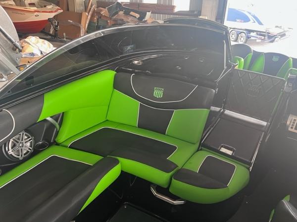 Slide: The Image of 2013 MasterCraft XStar boat interior with green and black seating. - 35