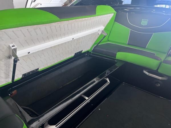 Slide: The Image of 2013 MasterCraft XStar boat interior with open storage compartment and green-black seating. - 36