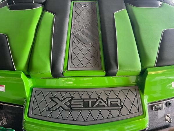 Slide: The Image of 2013 MasterCraft XStar boat with green and black seating and XStar branding. - 45