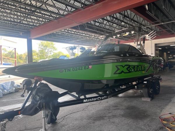Slide: The Image of 2013 MasterCraft XStar boat in green on a trailer in a covered storage area. - 5
